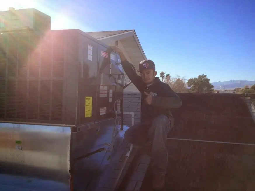 HVAC technician performing Air Duct Cleaning on a rooftop unit in Concord